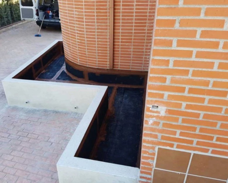 Protección impermeabilizante en una jardinera junto a un muro